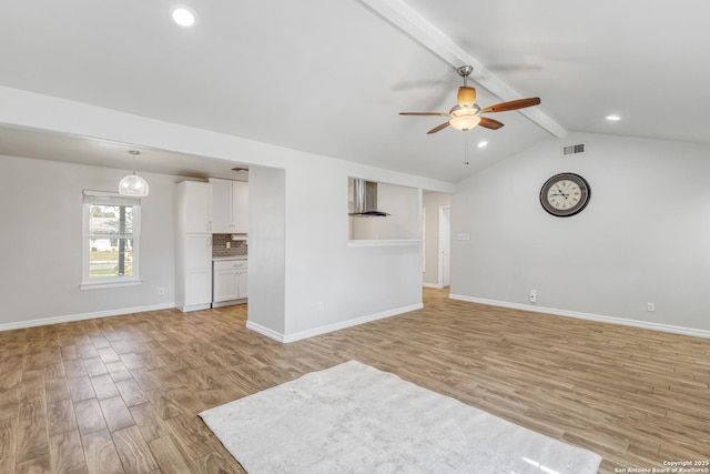 unfurnished living room with vaulted ceiling with beams, light hardwood / wood-style flooring, and ceiling fan