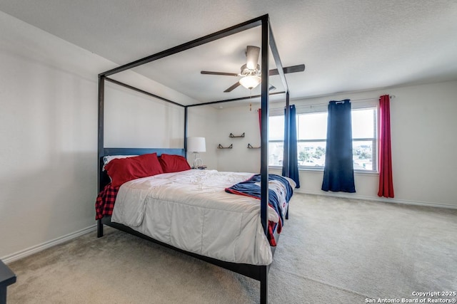 carpeted bedroom featuring ceiling fan and a textured ceiling