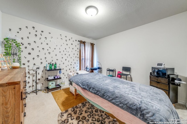 bedroom with light colored carpet and a textured ceiling