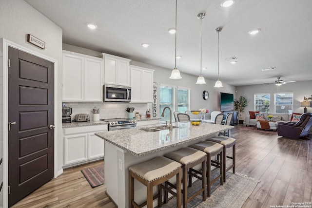 1274 Lennea, New Braunfels, TX 78130 - kitchen with sink, white cabinetry, hanging light fixtures, a center island with sink, and appliances with stainless steel finishes