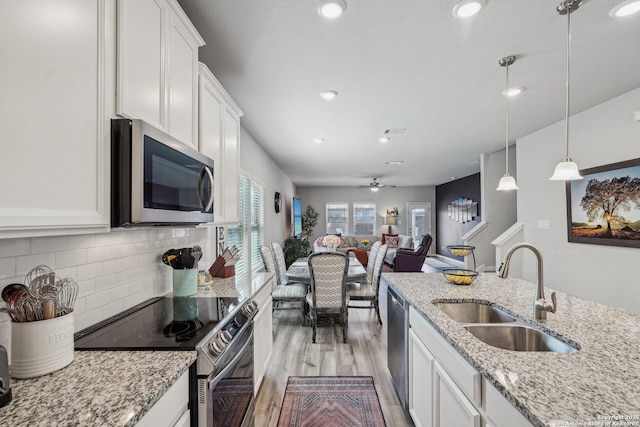 1274 Lennea, New Braunfels, TX 78130 - kitchen with sink, white cabinets, hanging light fixtures, light stone counters, and stainless steel appliances