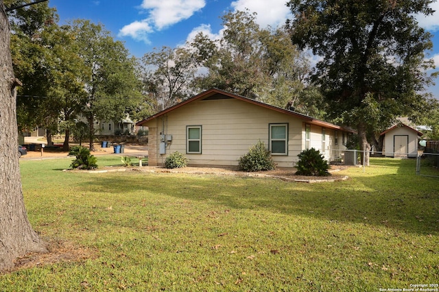 back of property featuring central air condition unit, a yard, and fence