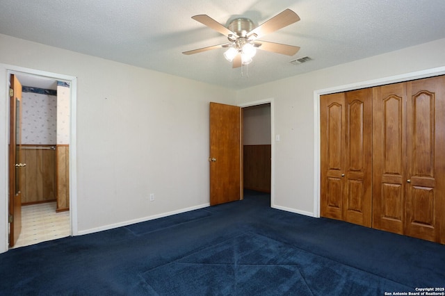 unfurnished bedroom featuring ceiling fan, carpet flooring, a textured ceiling, and a closet