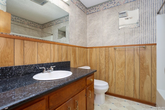 bathroom with vanity, toilet, and a textured ceiling