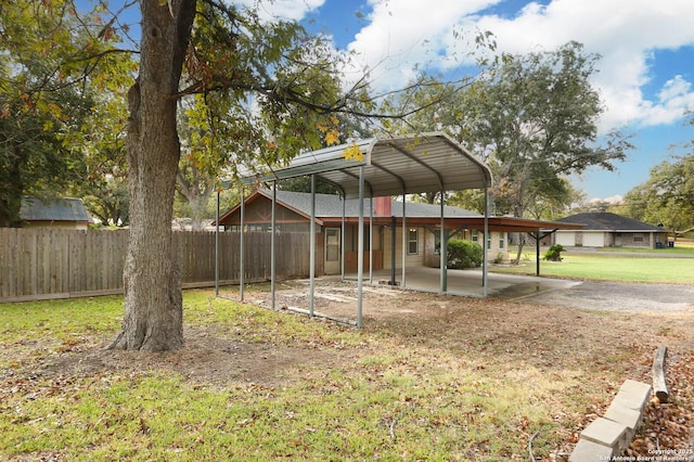 view of yard with a patio, a carport, and fence