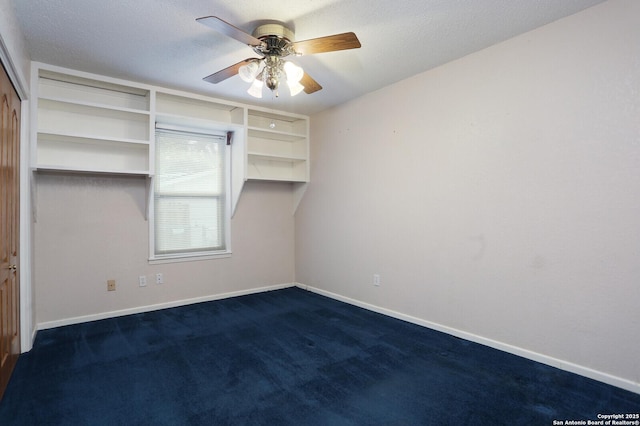 unfurnished bedroom with ceiling fan, dark carpet, and a textured ceiling