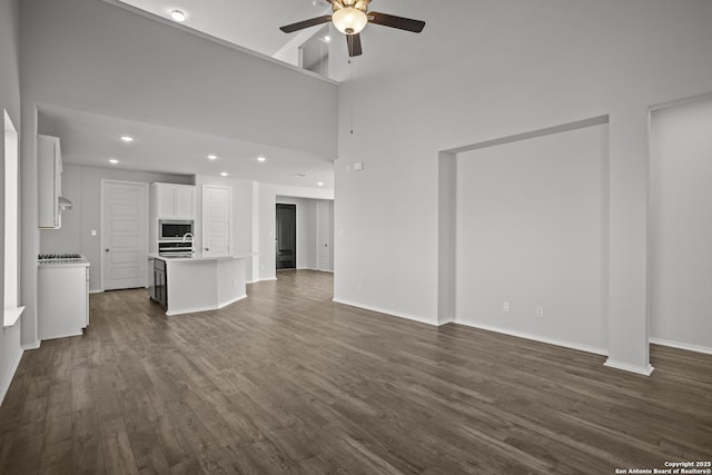 10257 Bartenheim Dr, Schertz, TX 78154 - unfurnished living room with a ceiling fan, dark wood-style flooring, recessed lighting, baseboards, and a sink