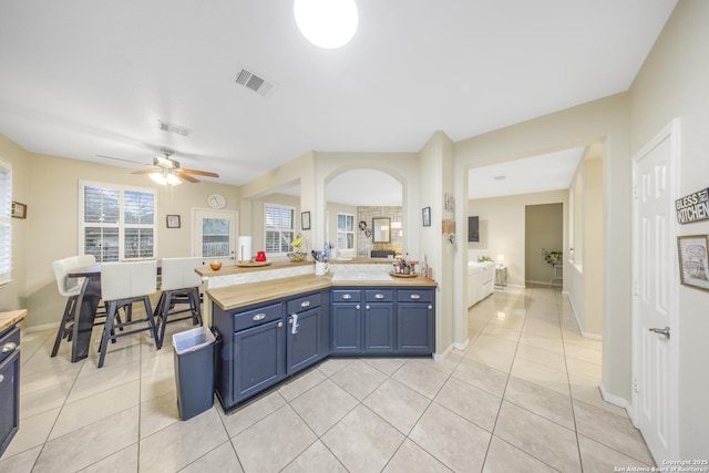 kitchen featuring blue cabinets, light tile patterned floors, and ceiling fan