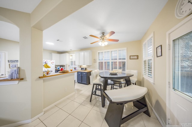 tiled dining space with ceiling fan