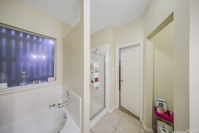 bathroom featuring tile patterned floors and shower with separate bathtub