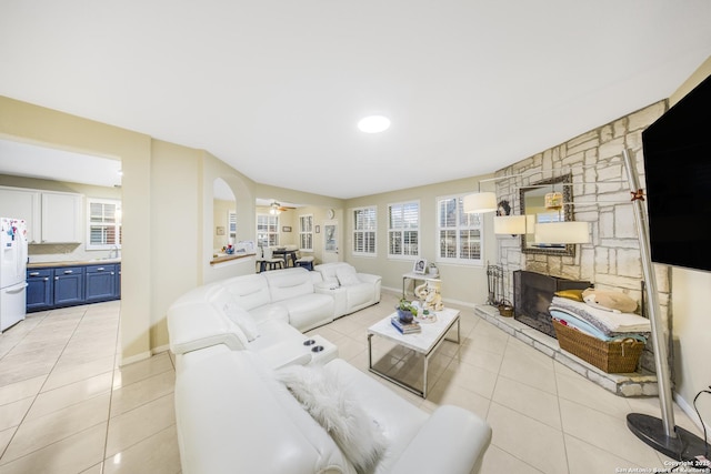 living room with ceiling fan, light tile patterned floors, and a fireplace