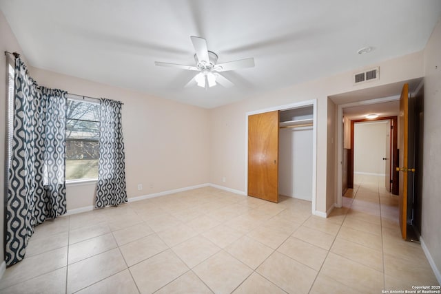 unfurnished bedroom with ceiling fan, a closet, and light tile patterned floors