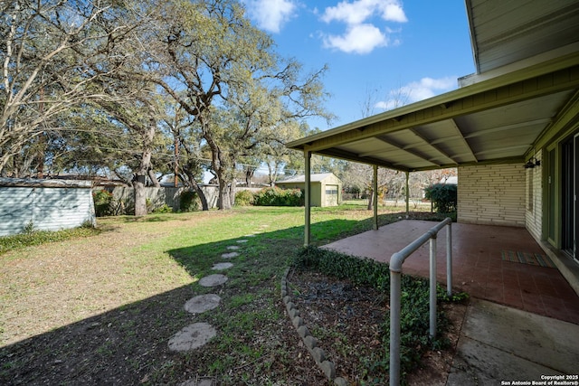 view of yard featuring a patio and a storage unit