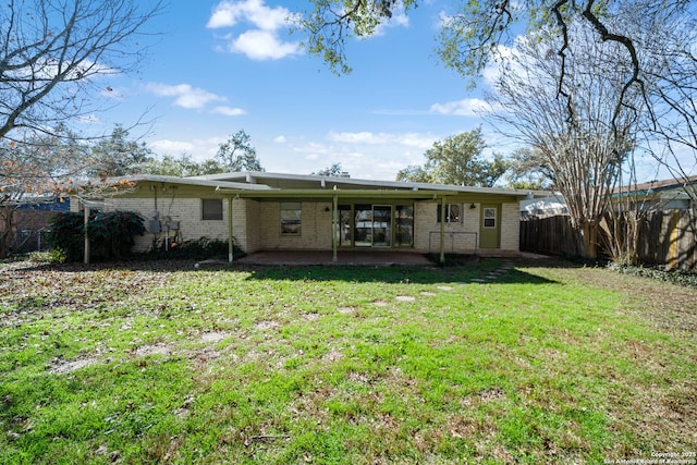 back of house with a patio and a lawn