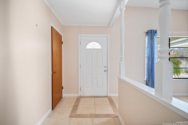 entryway with a wealth of natural light, ornate columns, and light tile patterned flooring