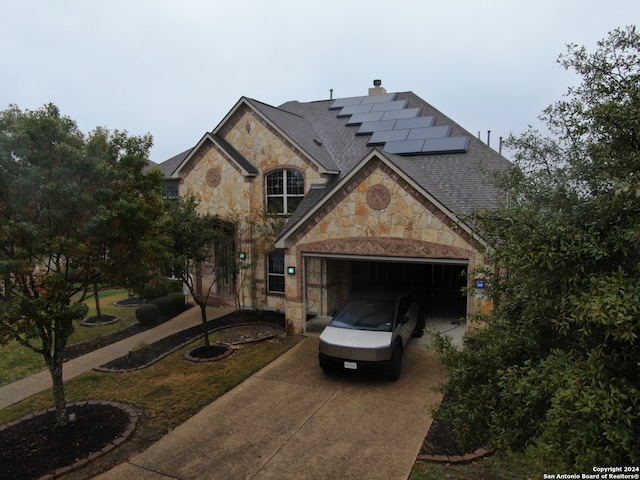 view of front of property featuring a garage and solar panels