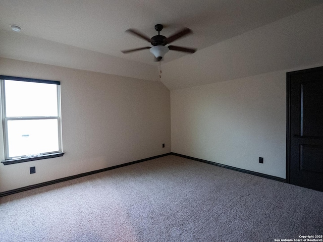 carpeted empty room featuring lofted ceiling and ceiling fan