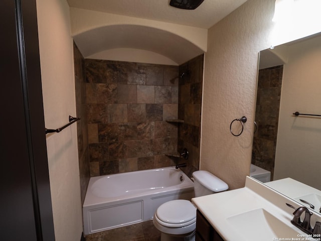 full bathroom with tiled shower / bath combo, vanity, and toilet