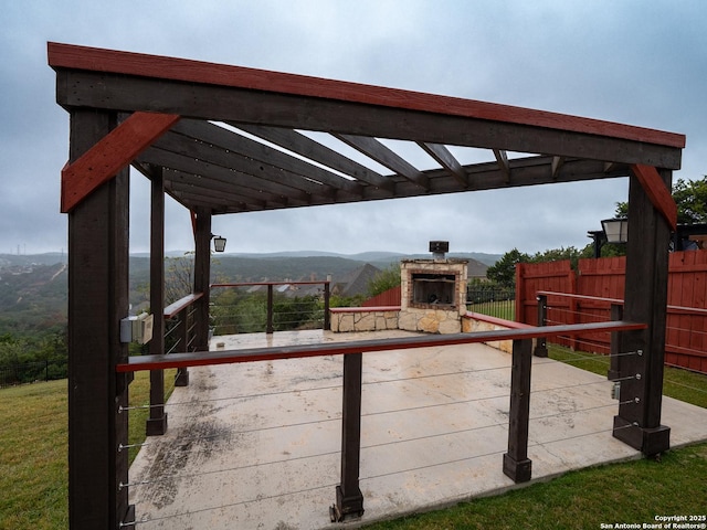 wooden deck with a mountain view and an outdoor stone fireplace