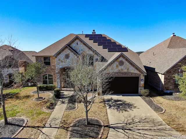 view of front of house featuring a garage and solar panels