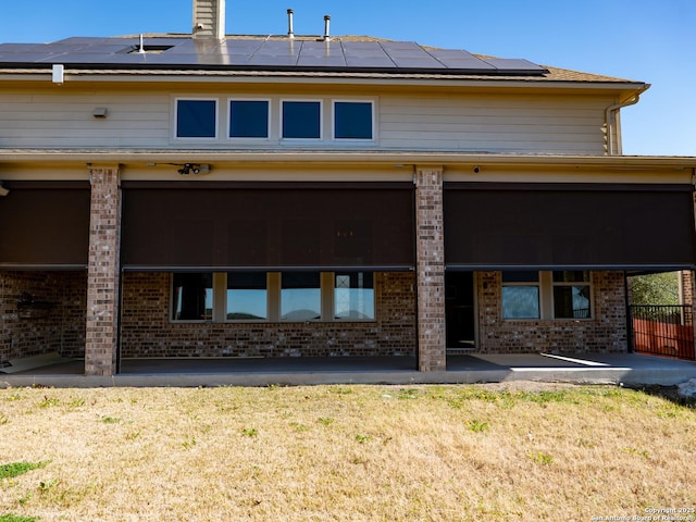 back of house with a patio area and solar panels