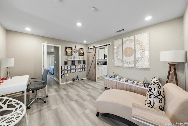 interior space with a barn door and light wood-type flooring