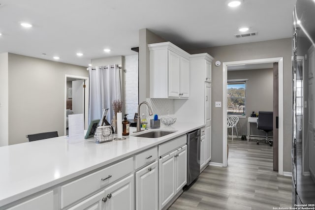 kitchen with white cabinetry, dishwasher, sink, and light hardwood / wood-style flooring