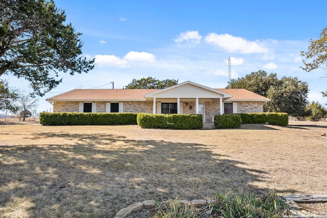 ranch-style home with covered porch and a front yard