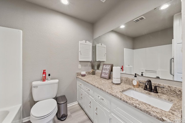 bathroom with vanity, toilet, and hardwood / wood-style floors