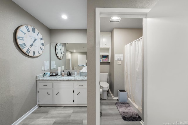 bathroom featuring vanity, toilet, and curtained shower