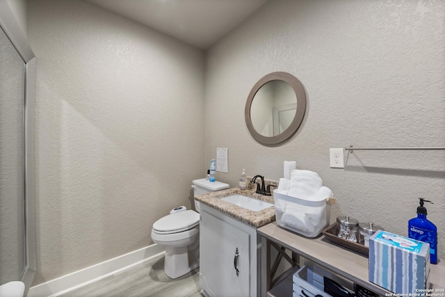 bathroom with vanity, hardwood / wood-style floors, and toilet