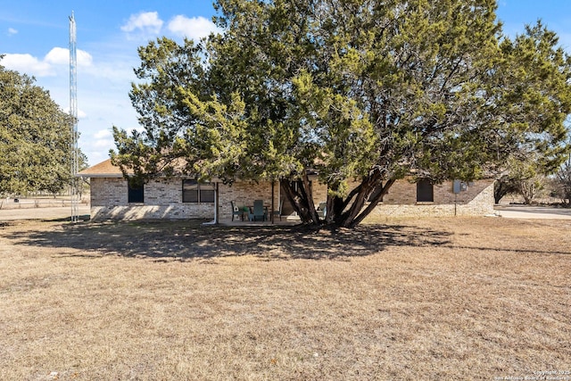 view of property hidden behind natural elements featuring a front lawn