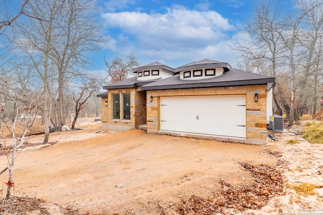 view of front of house with a garage and central AC