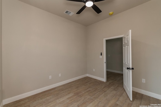 empty room with ceiling fan and light wood-type flooring