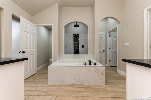 bathroom featuring vaulted ceiling, separate shower and tub, and toilet