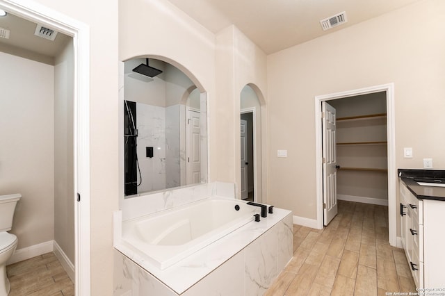 full bathroom featuring vanity, shower with separate bathtub, and toilet