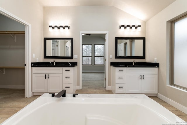 bathroom featuring lofted ceiling and vanity