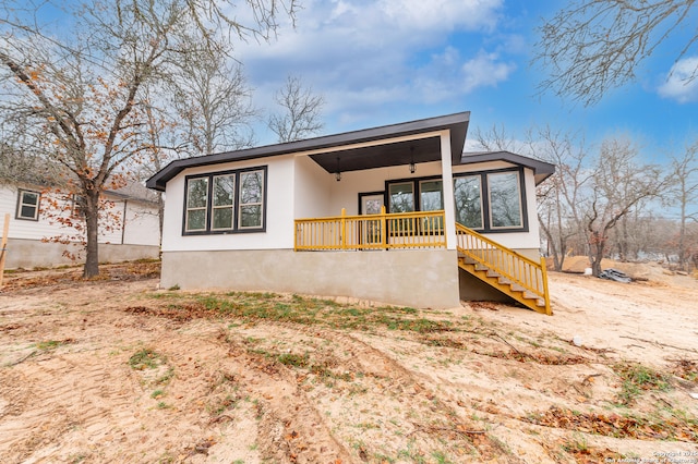 back of house with ceiling fan and covered porch