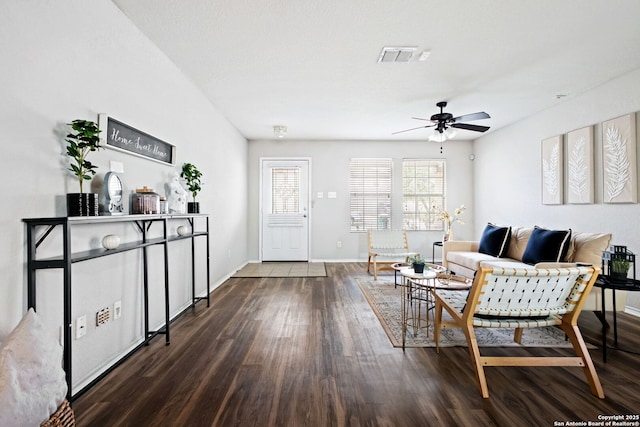 living room featuring dark wood-type flooring and ceiling fan