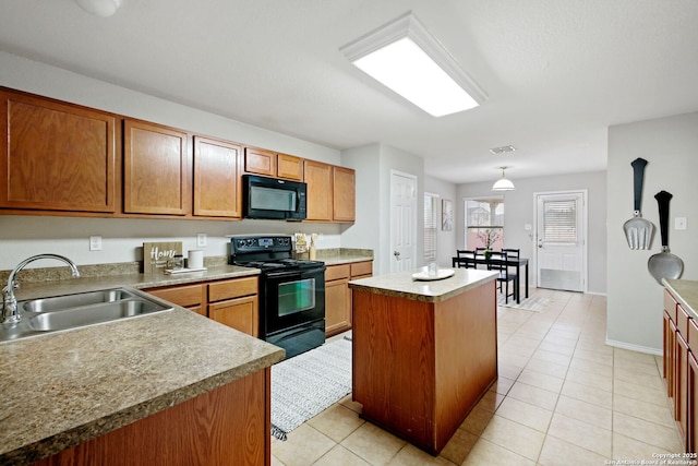 kitchen featuring light tile patterned floors, sink, a kitchen island, and black appliances