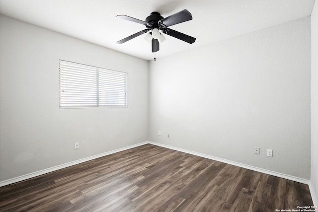 spare room featuring dark wood-type flooring and ceiling fan