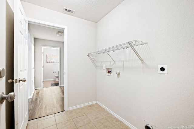 laundry room featuring light tile patterned floors, hookup for a washing machine, a textured ceiling, hookup for a gas dryer, and hookup for an electric dryer