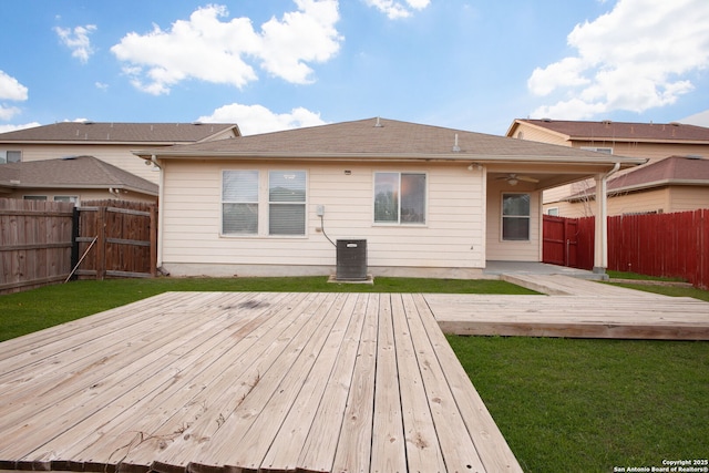 back of property featuring a wooden deck, ceiling fan, and a yard