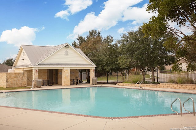 view of pool with an outdoor structure, central AC, and a patio area