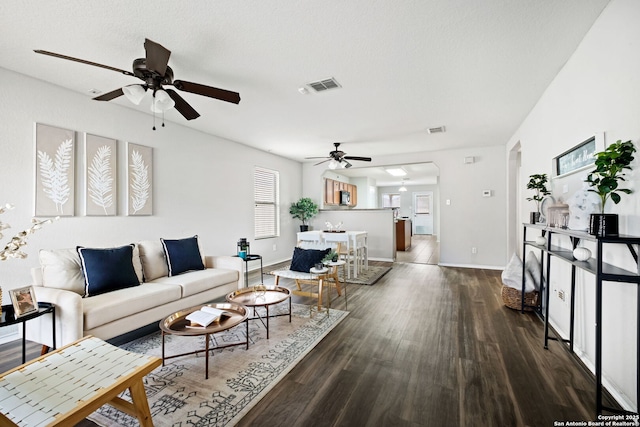 living room with ceiling fan and dark hardwood / wood-style flooring