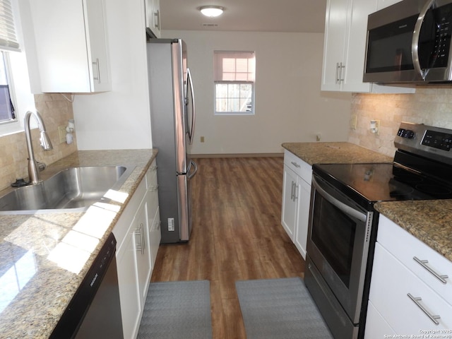 kitchen with white cabinetry, appliances with stainless steel finishes, sink, and light stone counters