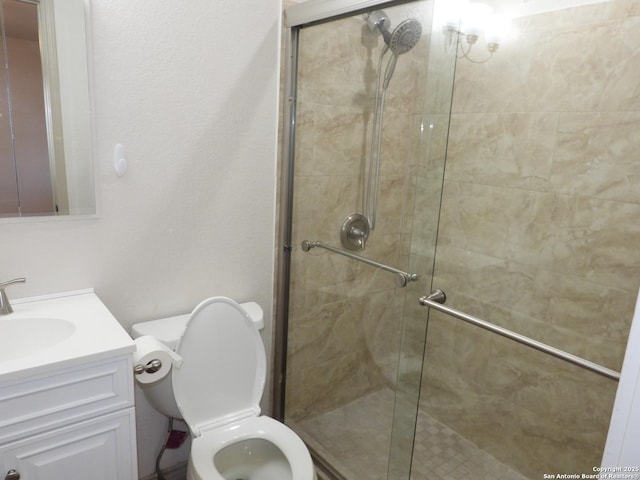 bathroom featuring vanity, toilet, and a shower with shower door