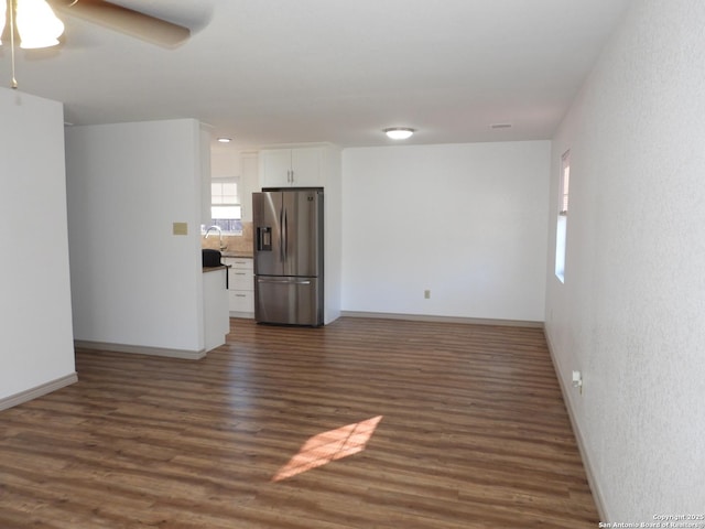 unfurnished living room with dark wood-type flooring, ceiling fan, and sink