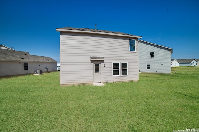 rear view of house featuring a yard and cooling unit