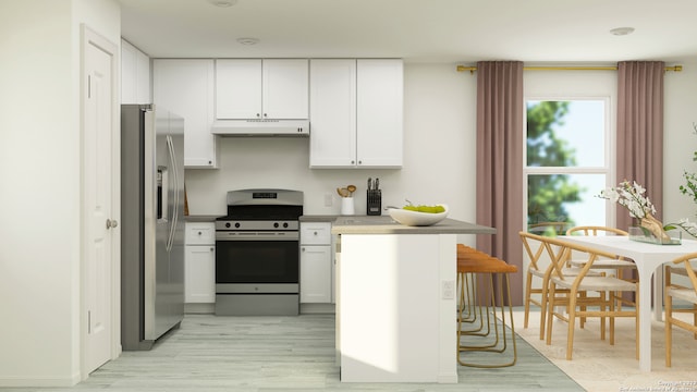 kitchen with appliances with stainless steel finishes, light hardwood / wood-style flooring, a breakfast bar area, and white cabinets